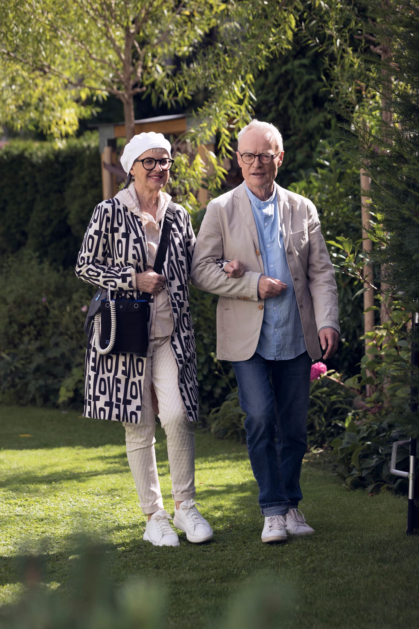 Smiling middle-aged man wearing glasses and a dark shirt in a bright indoor setting
