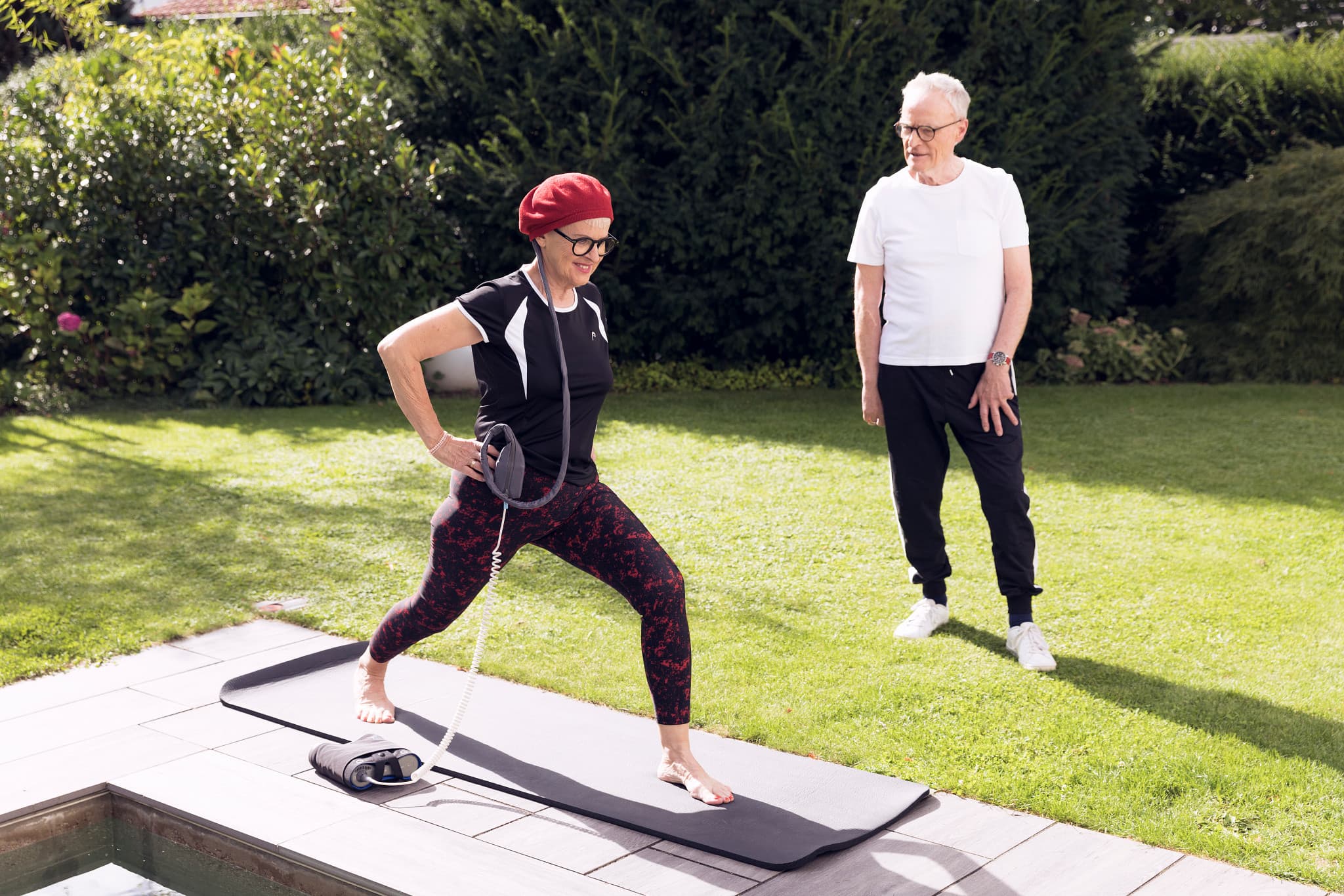 Close-up of a smiling young man with short hair wearing a white t-shirt outdoors